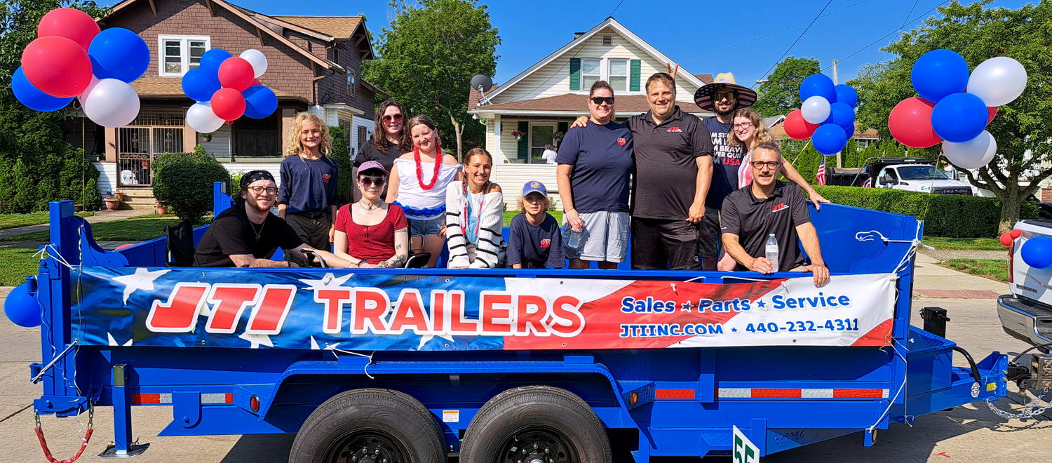 JTI Trailers crew in 4th of July float blue dump trailer before Bedford parade